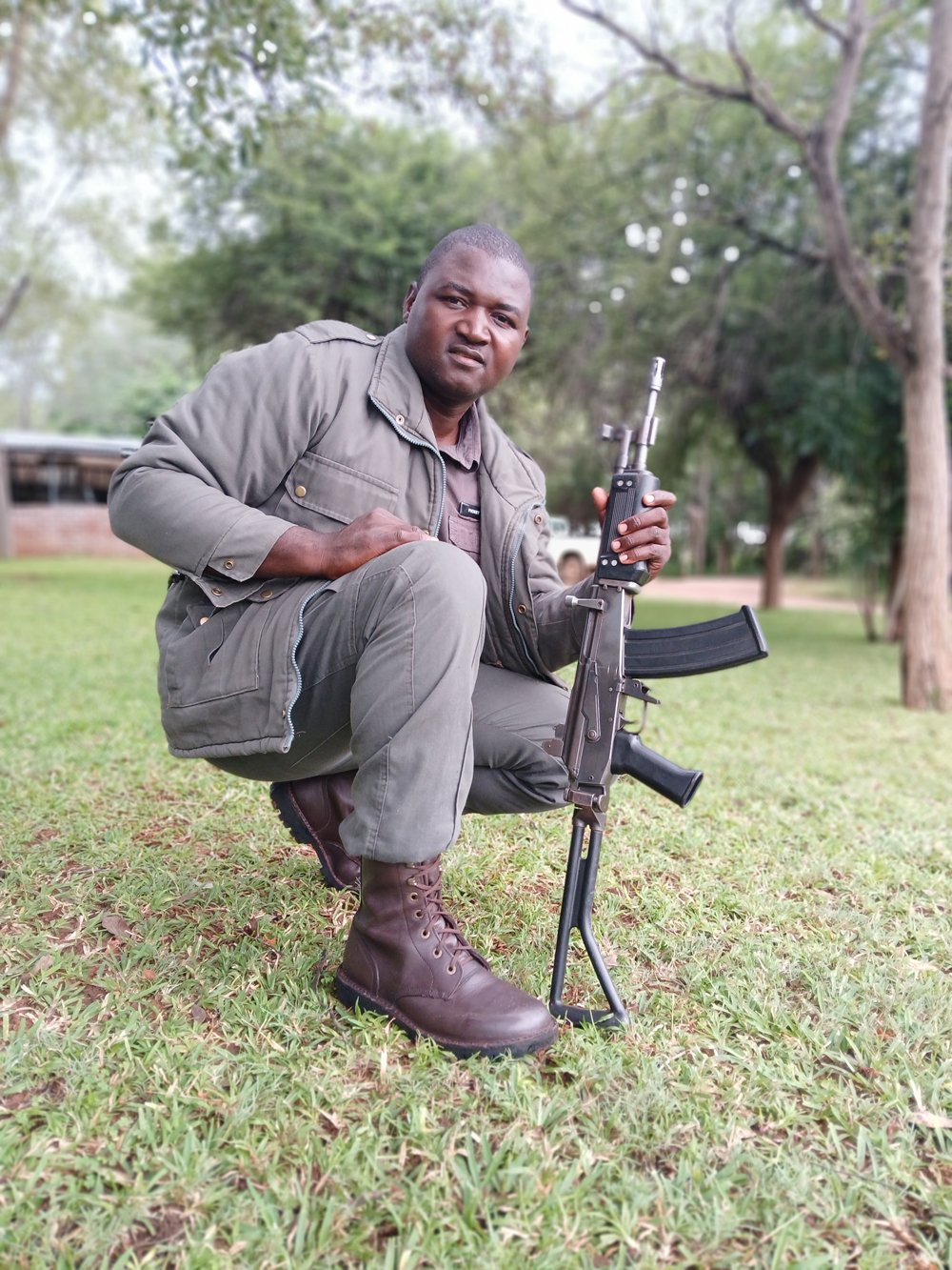 Picket kneeling in the grass holding a rifle